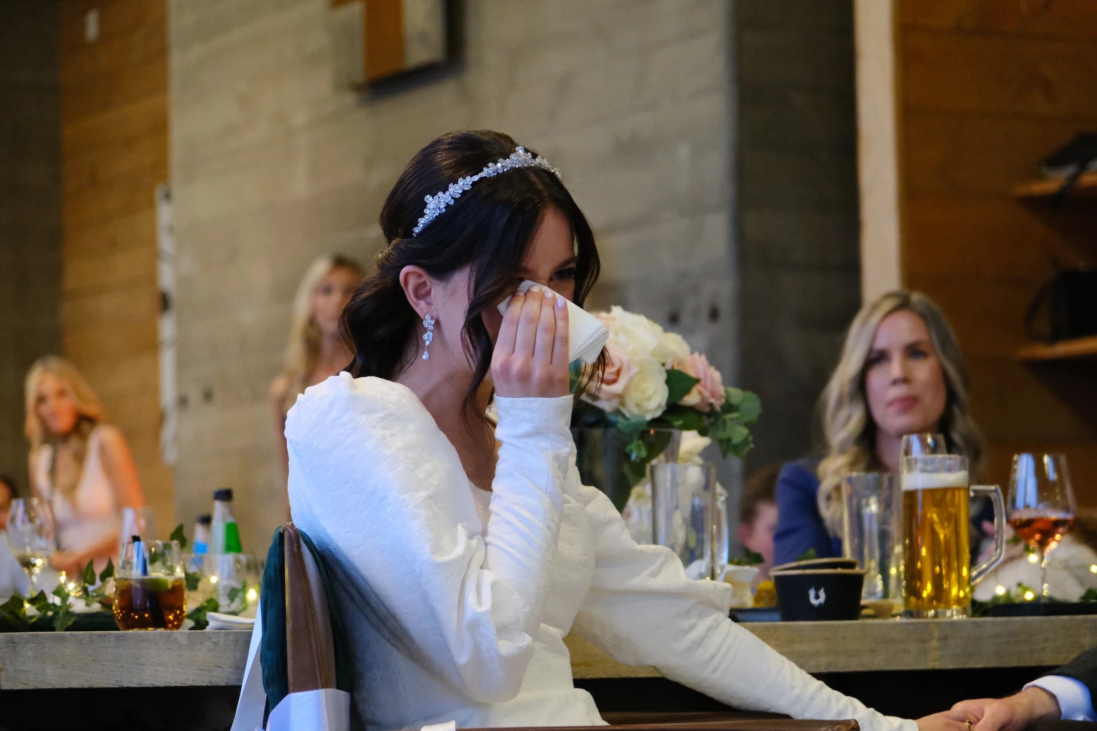 A bride wipes away a tear during her wedding reception